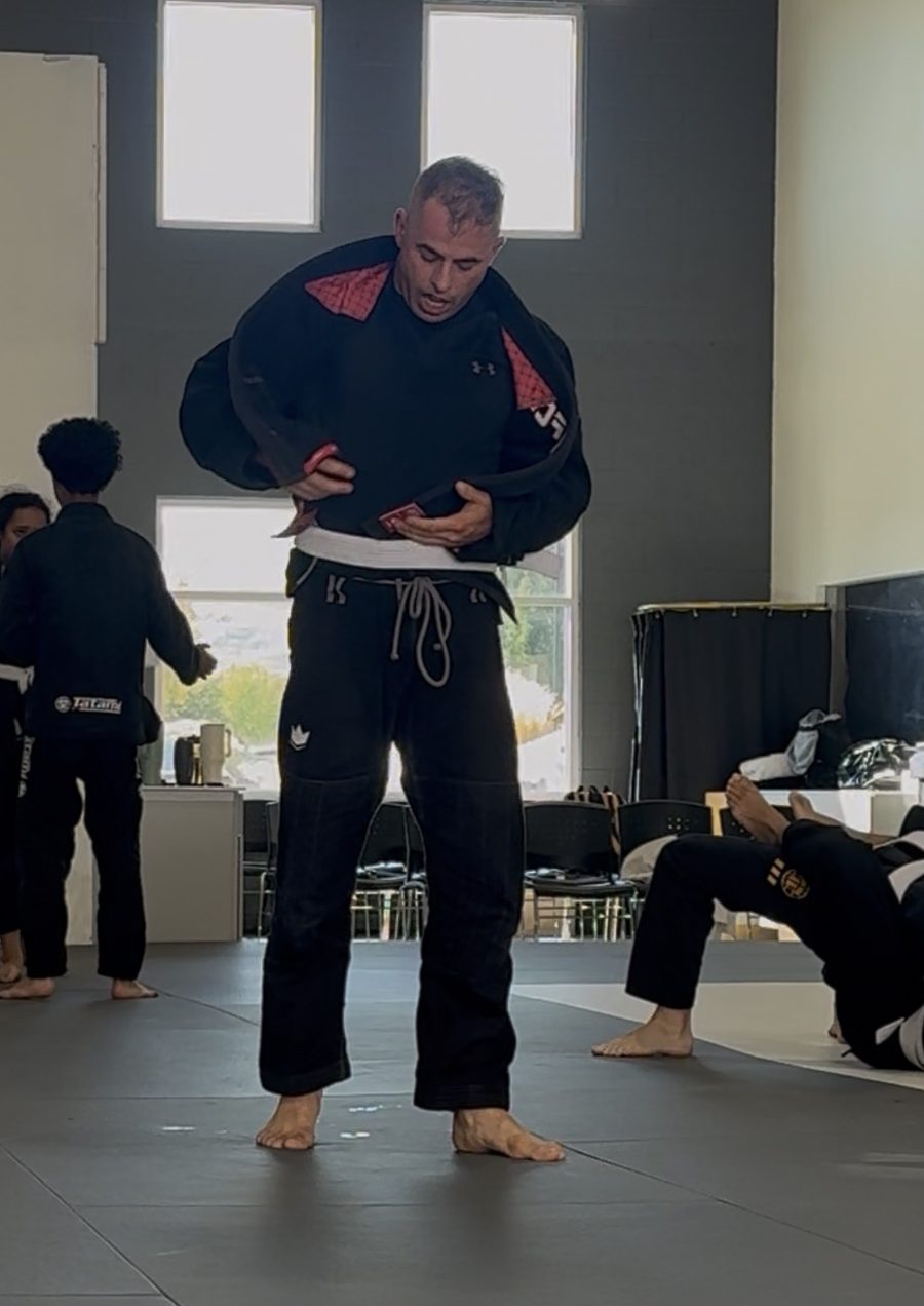 Emanuel tying his belt on the mats before training