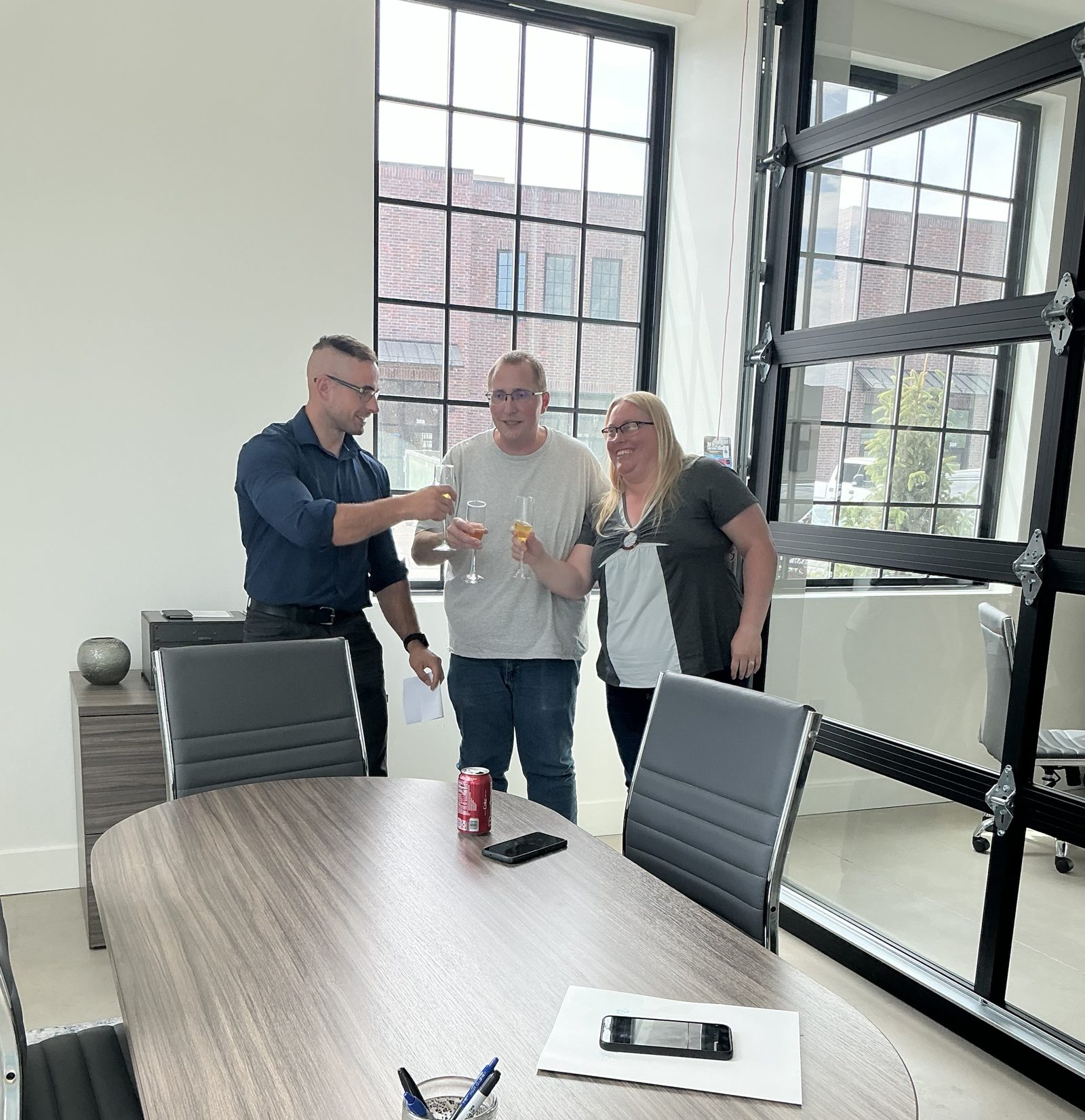 Emanuel toasting with two clients at a closing table